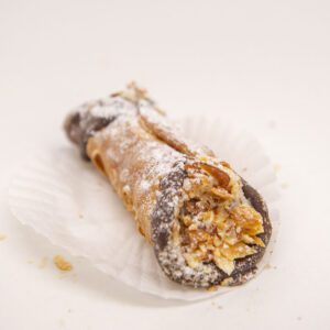 Crisp shells filled with sweetened ricotta cheese and chocolate chips, the ends are dipped in chocolate and almonds.